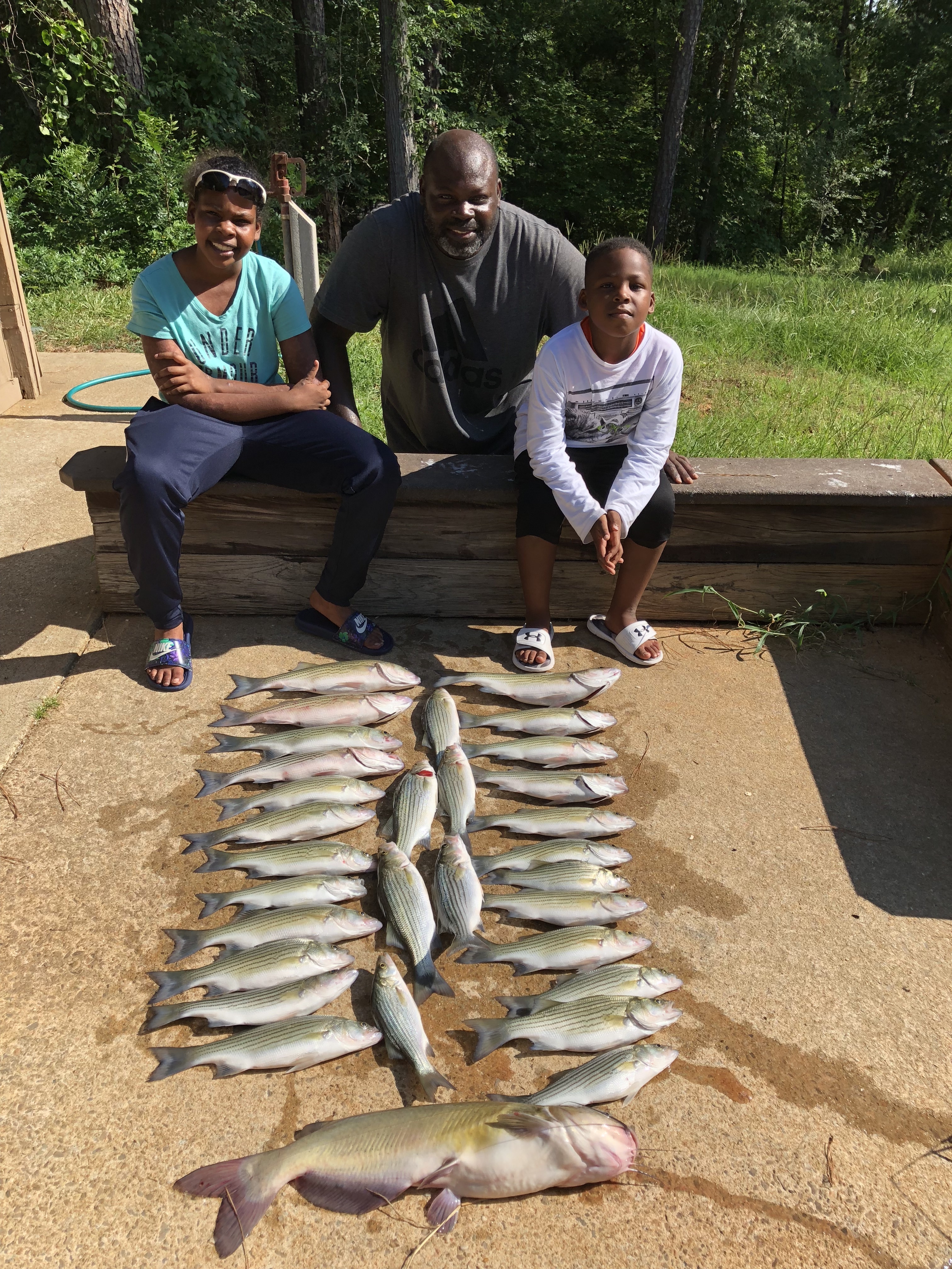 Roy Edmond and his Daughter, Simone and his son Trey with their limit of hybrid and stripers.IMG_2221